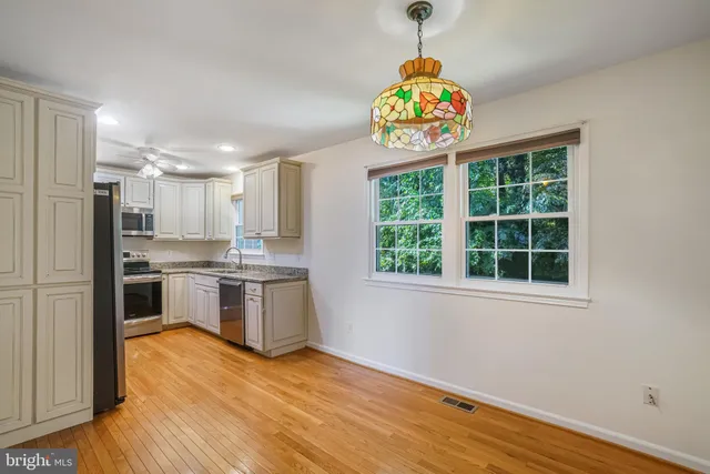 a kitchen with a stove a refrigerator and a window