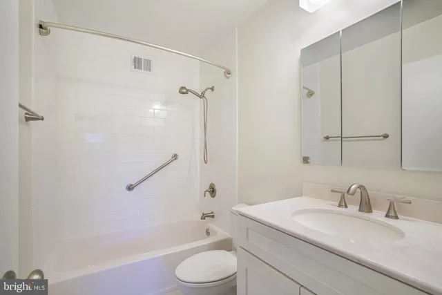 a bathroom with a granite countertop sink toilet a mirror and shower