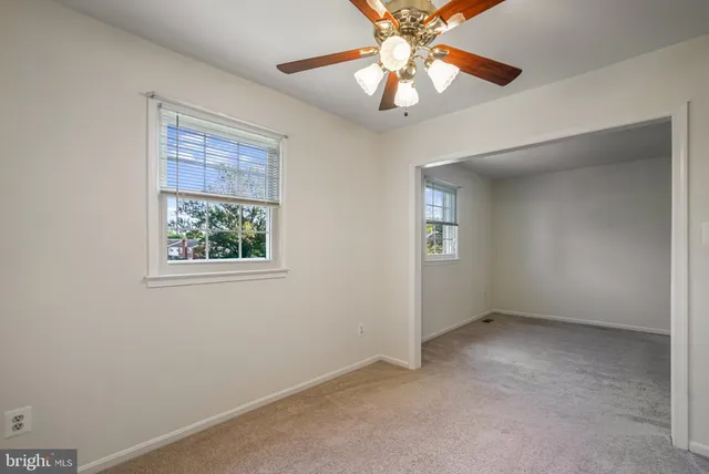 an empty room with a window and a fan