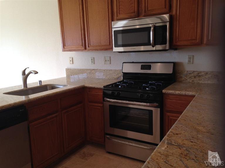 876 Congressional Road Simi Valley, CA 93065 - Photo 3 of 19 a kitchen with stainless steel appliances a stove a microwave a sink and cabinets