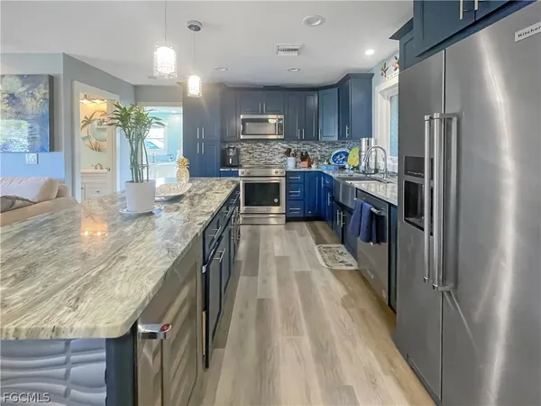 a kitchen with granite countertop stainless steel appliances cabinets a sink and a counter