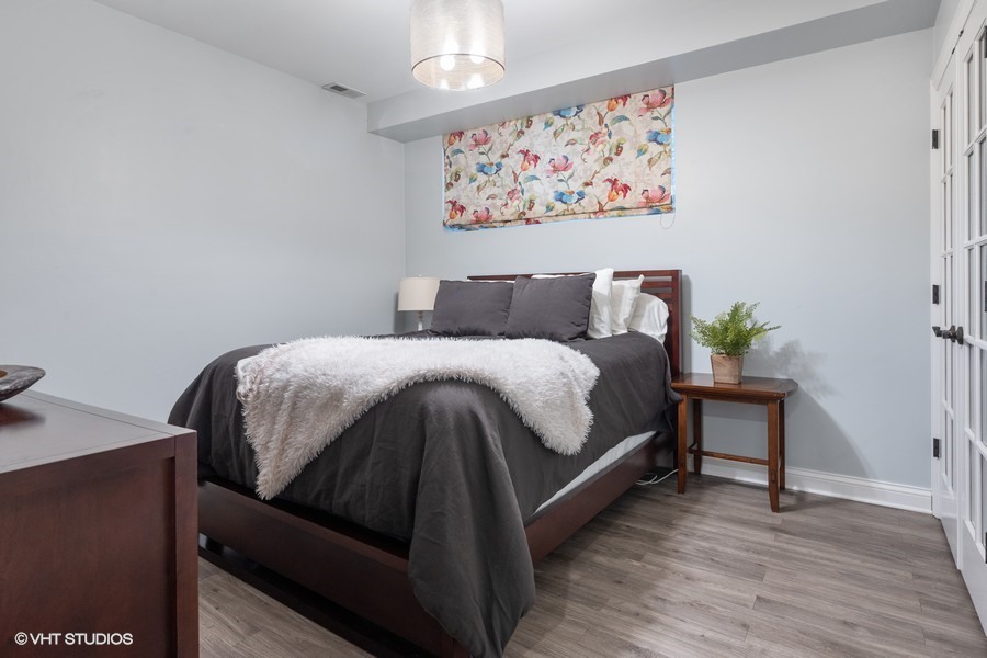 1316 West Fletcher Street, Unit 1E Chicago, IL 60657 - Photo 11 of 13 a bedroom with a bed and a painting on the wall