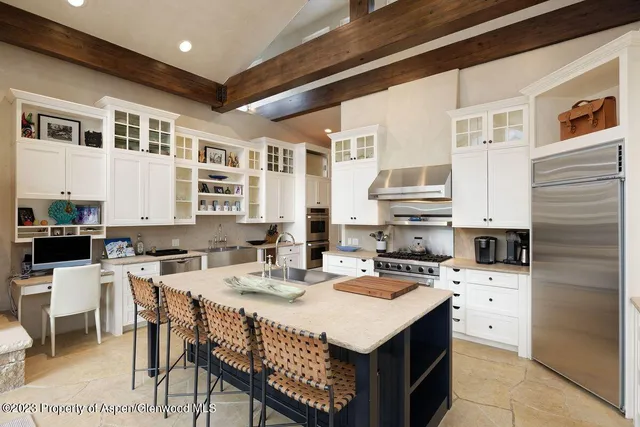 a kitchen with a stove a sink a dining table and chairs