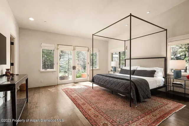 a bed sitting in a spacious bedroom next to a window