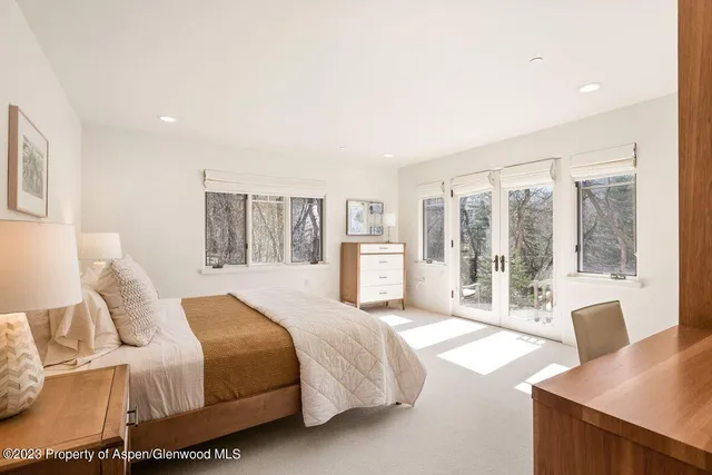 a spacious bedroom with a large bed and a large window