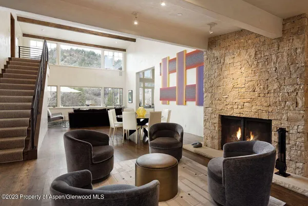 a living room with furniture a fireplace and a floor to ceiling window