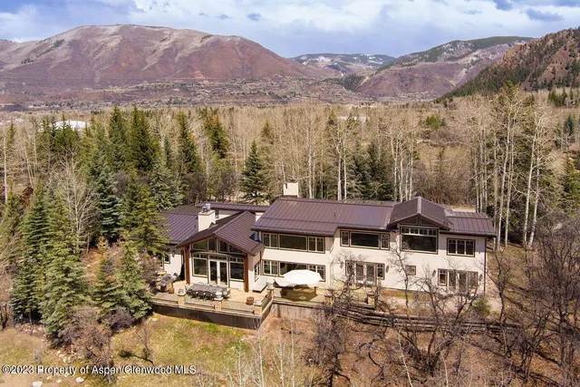 a front view of a house with a yard and mountain view