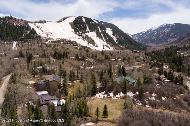 a view of a house with a mountain and a forest