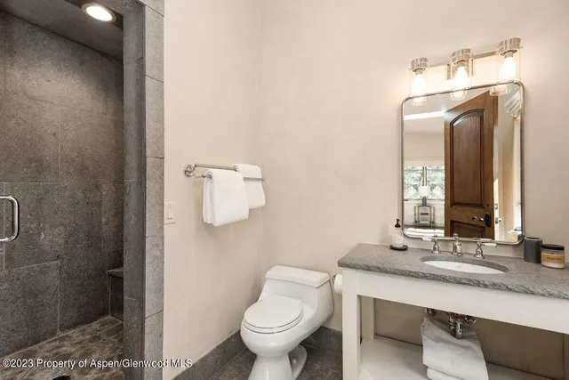 a bathroom with a toilet sink and mirror
