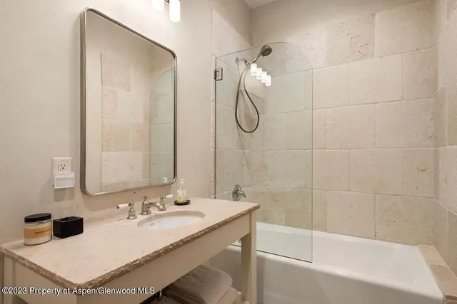 a bathroom with a tub sink and mirror