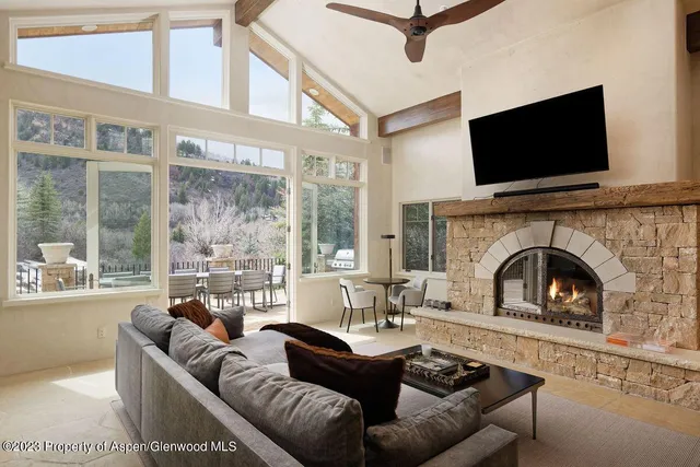 a living room with furniture a flat screen tv and a fireplace
