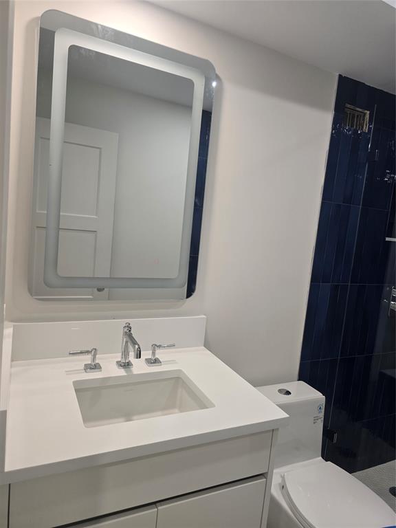 328 North Ocean Boulevard, Unit 501 Pompano Beach, FL 33062 - Photo 13 of 17 a bathroom with a sink toilet and mirror