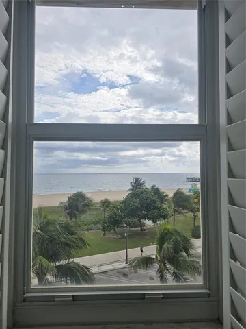 a view of an empty room with closet and a window