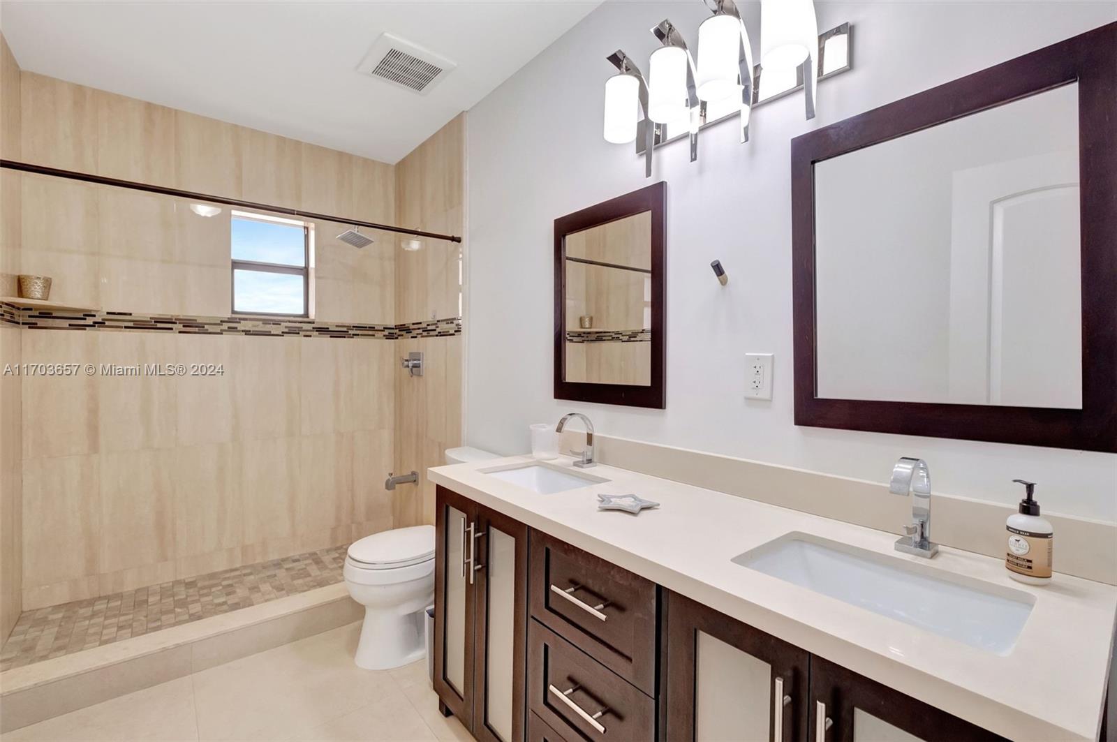141 Southwest 51st Court, Unit 141 Miami, FL 33134 - Photo 20 of 38 a bathroom with a double vanity sink mirror and toilet
