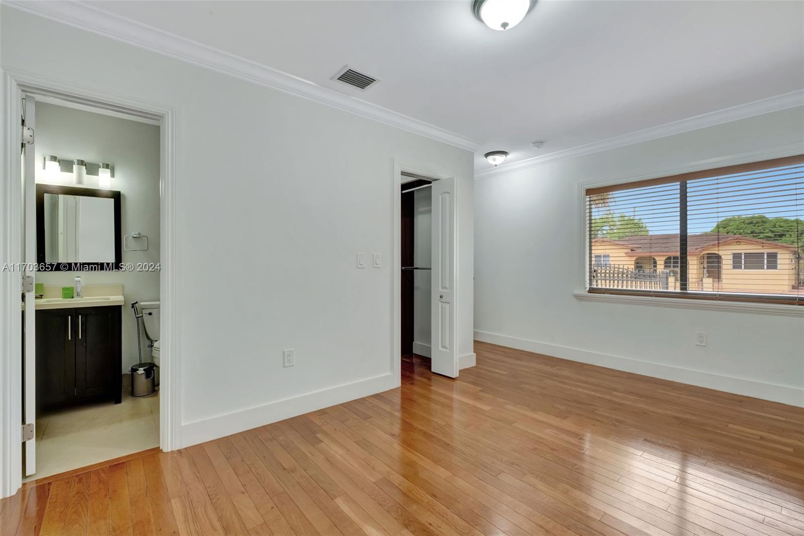 141 Southwest 51st Court, Unit 141 Miami, FL 33134 - Photo 24 of 38 wooden floor in an empty room with a window