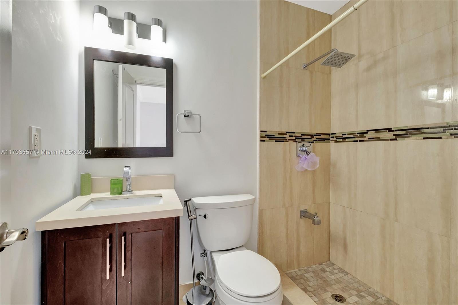 141 Southwest 51st Court, Unit 141 Miami, FL 33134 - Photo 25 of 38 a bathroom with a toilet a sink and mirror