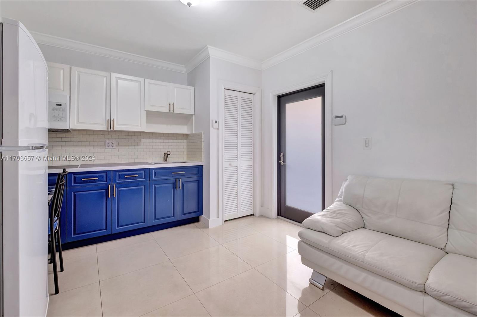 141 Southwest 51st Court, Unit 141 Miami, FL 33134 - Photo 30 of 38 a living room with furniture a kitchen island with wooden cabinets