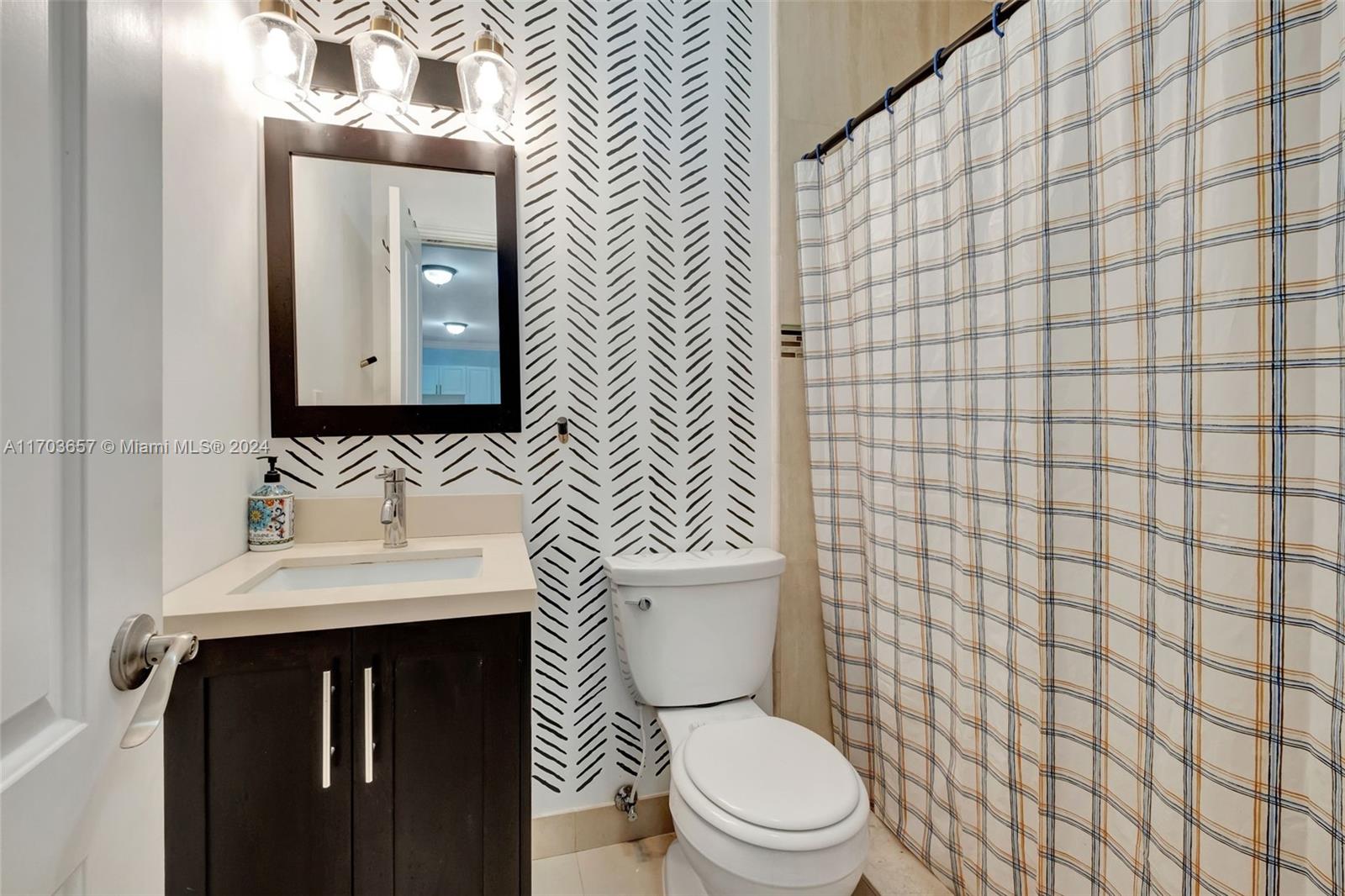 141 Southwest 51st Court, Unit 141 Miami, FL 33134 - Photo 31 of 38 a bathroom with a sink a toilet and mirror
