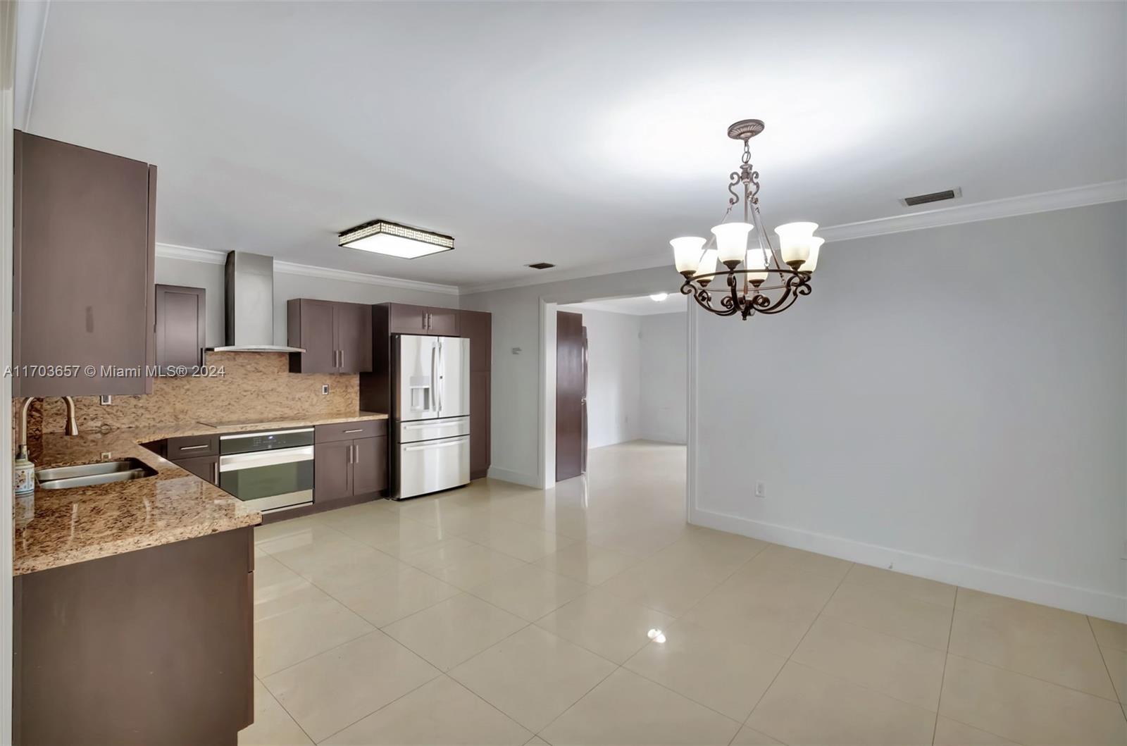 141 Southwest 51st Court, Unit 141 Miami, FL 33134 - Photo 6 of 38 a kitchen with granite countertop stainless steel appliances a stove top oven a sink and dishwasher