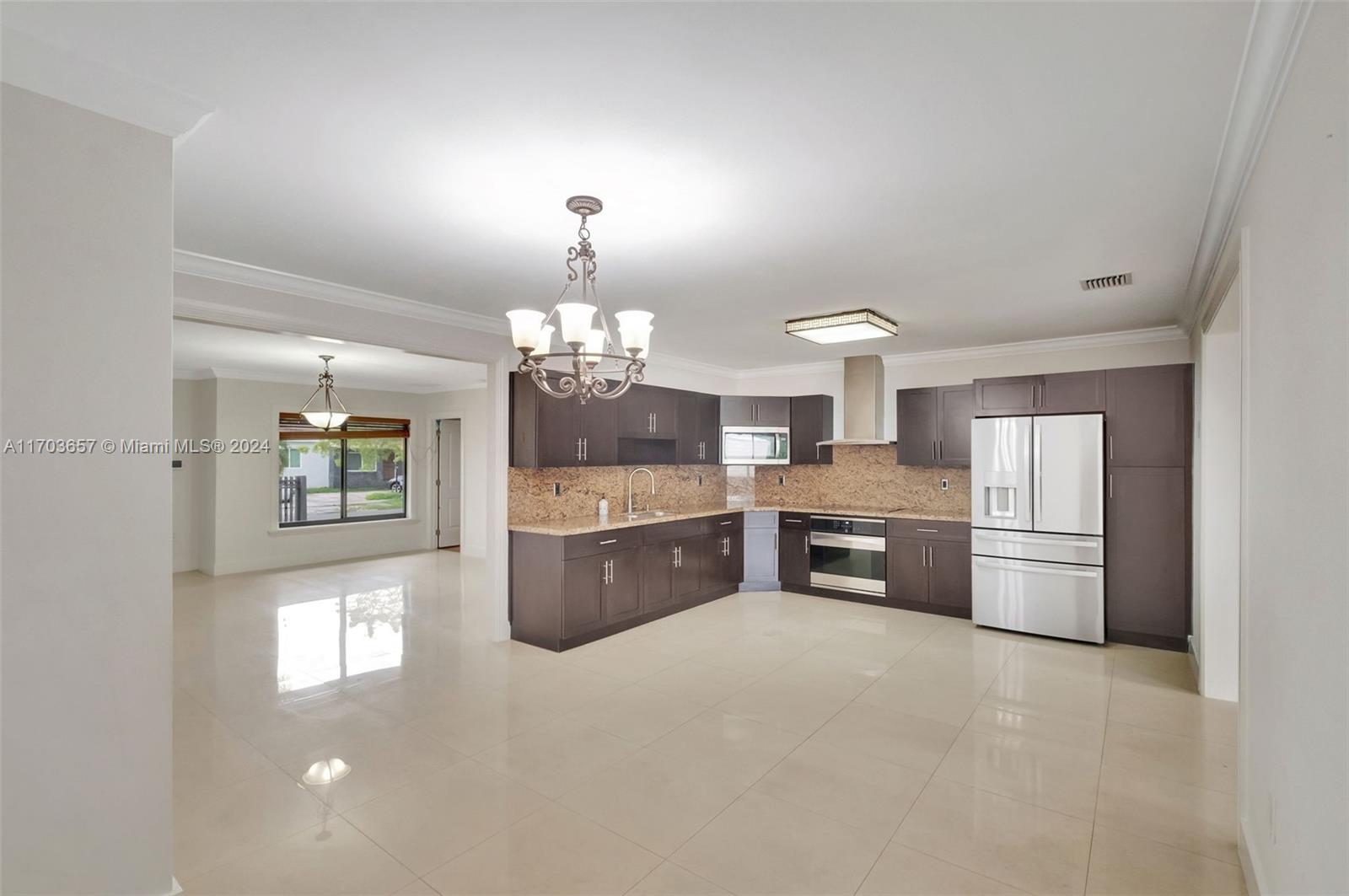 141 Southwest 51st Court, Unit 141 Miami, FL 33134 - Photo 7 of 38 a large kitchen with lot of cabinets and refrigerator