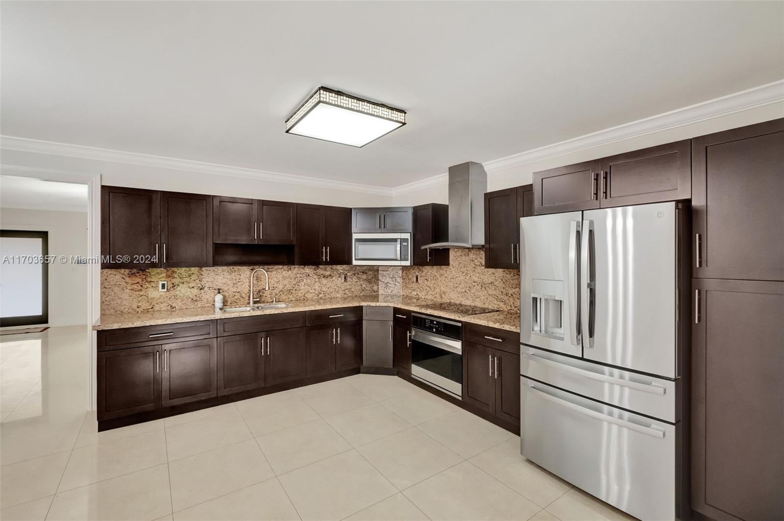 141 Southwest 51st Court, Unit 141 Miami, FL 33134 - Photo 8 of 38 a kitchen with stainless steel appliances kitchen island granite countertop a refrigerator and a stove