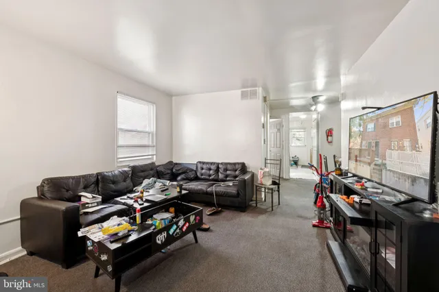 a living room with furniture a flat screen tv and a window