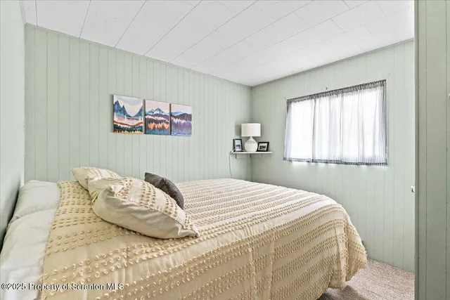 a bedroom with a bed and a painting on the wall