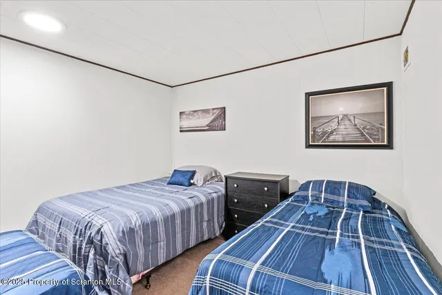 a bedroom with two beds and a lamp on the wall