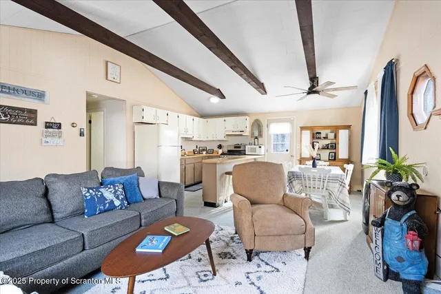 a living room with furniture kitchen view and a chandelier