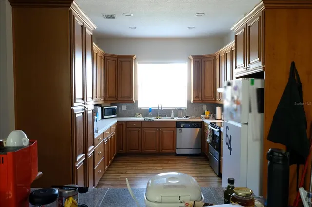 a view of a hallway with wooden floor and a window