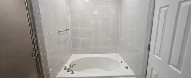 a bathroom with a granite countertop sink and a mirror with bathtub