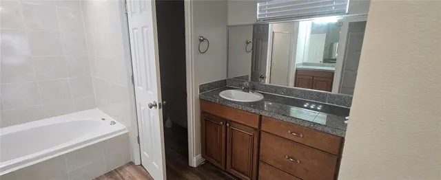 a bathroom with a tub shower and sink
