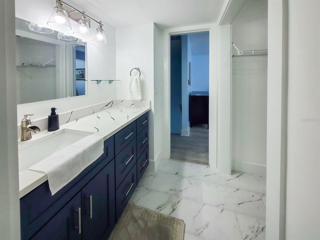215 Medallion Boulevard, Unit G Madeira Beach, FL 33708 - Photo 16 of 29 a bathroom with a double vanity sink and a mirror