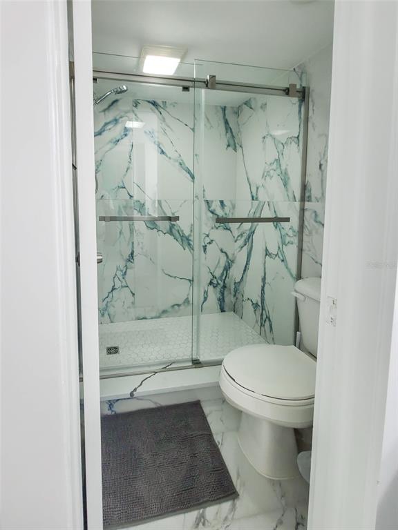 215 Medallion Boulevard, Unit G Madeira Beach, FL 33708 - Photo 18 of 29 a bathroom with a toilet and a shower