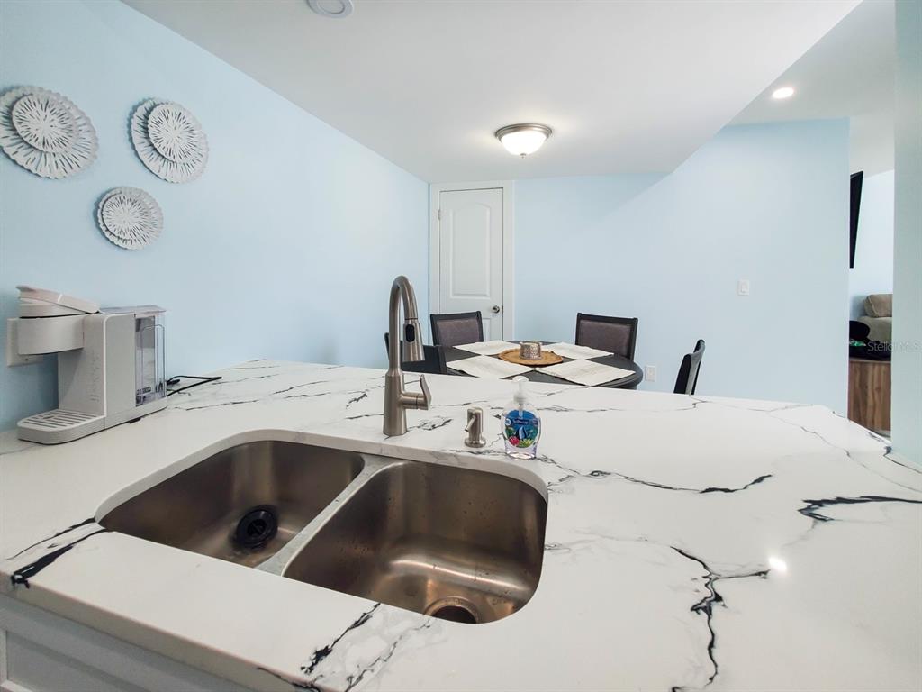 215 Medallion Boulevard, Unit G Madeira Beach, FL 33708 - Photo 8 of 29 a kitchen with a sink and a stove top oven