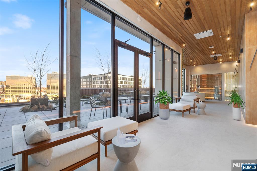 65 McWhorter Street, Unit 711 Newark, NJ 07105 - Photo 3 of 14 a living room with furniture and a floor to ceiling window