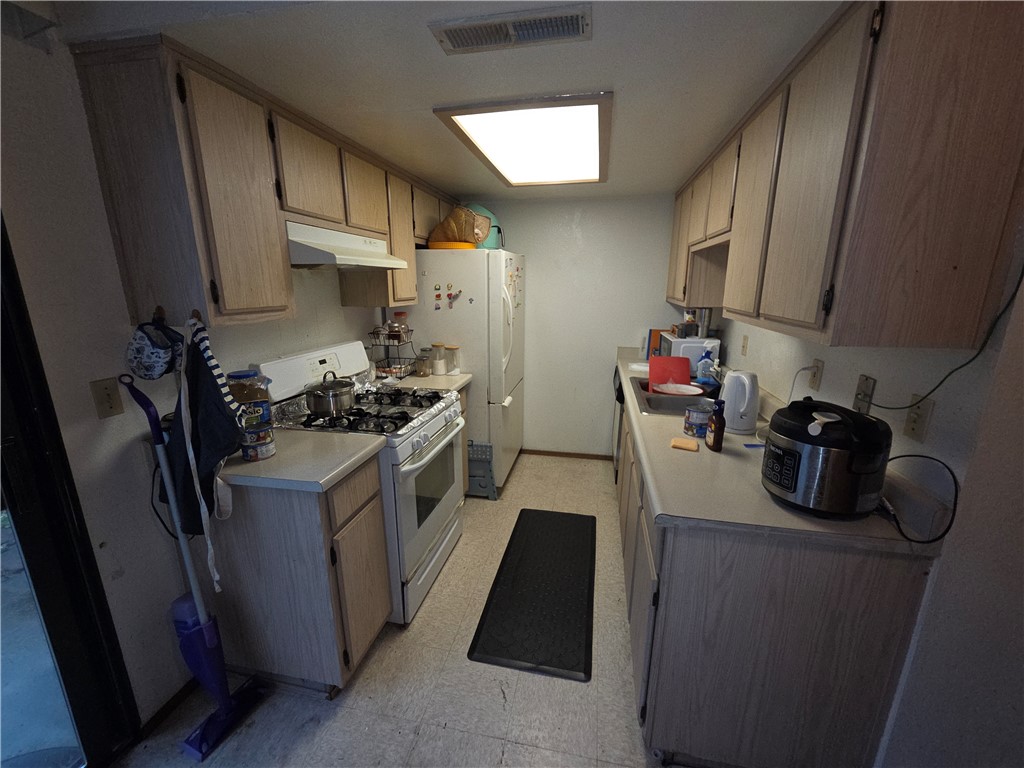 635 North Street Corning, CA 96021 - Photo 11 of 29 a kitchen with a refrigerator stove and wooden cabinets