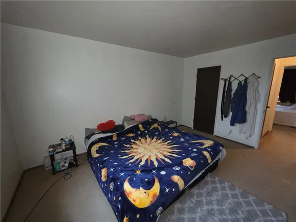 a bed sitting in a bedroom next to a lamp
