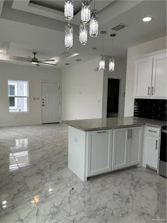 a view of a kitchen with a sink and chandelier