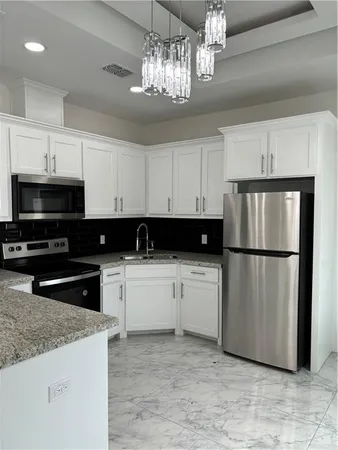 a kitchen with a refrigerator a microwave a sink and cabinets