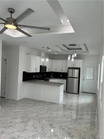 a kitchen with stainless steel appliances a refrigerator a sink a stove a microwave and cabinets