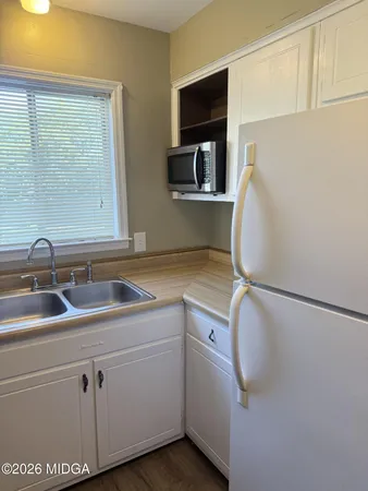 a kitchen with granite countertop a stove and a white cabinets