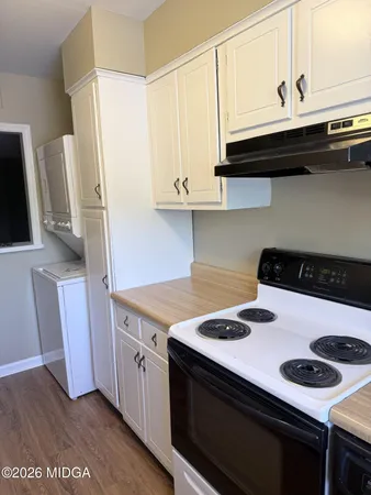 a kitchen with a stove cabinets and a wooden floor