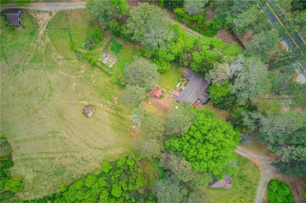 an aerial view of residential house with outdoor space and trees all around