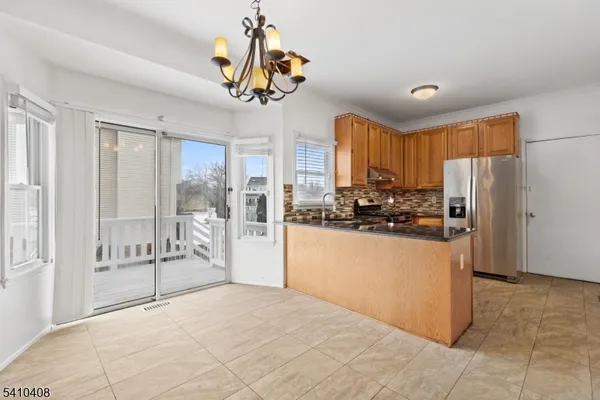 a kitchen with stainless steel appliances granite countertop a refrigerator and a stove top oven