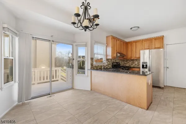 a view of a kitchen with refrigerator and windows
