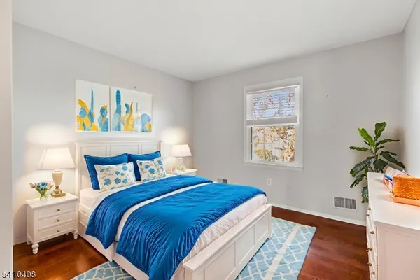 a bedroom with a bed and painting on the wall