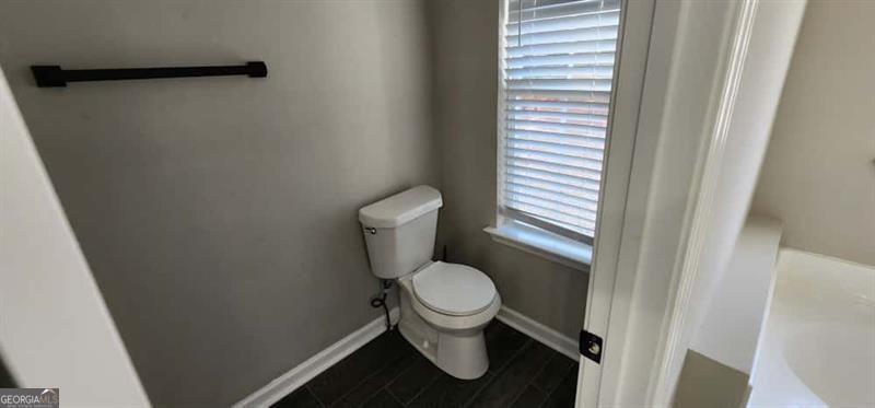4872 Lewis Road Powder Springs, GA 30127 - Photo 20 of 42 a white toilet sitting in a bathroom next to a sink