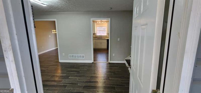 4872 Lewis Road Powder Springs, GA 30127 - Photo 7 of 42 a view of a hallway with wooden floor and a bathroom