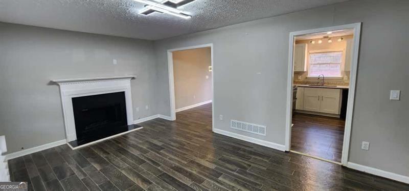 4872 Lewis Road Powder Springs, GA 30127 - Photo 8 of 42 an empty room with wooden floor fireplace and windows
